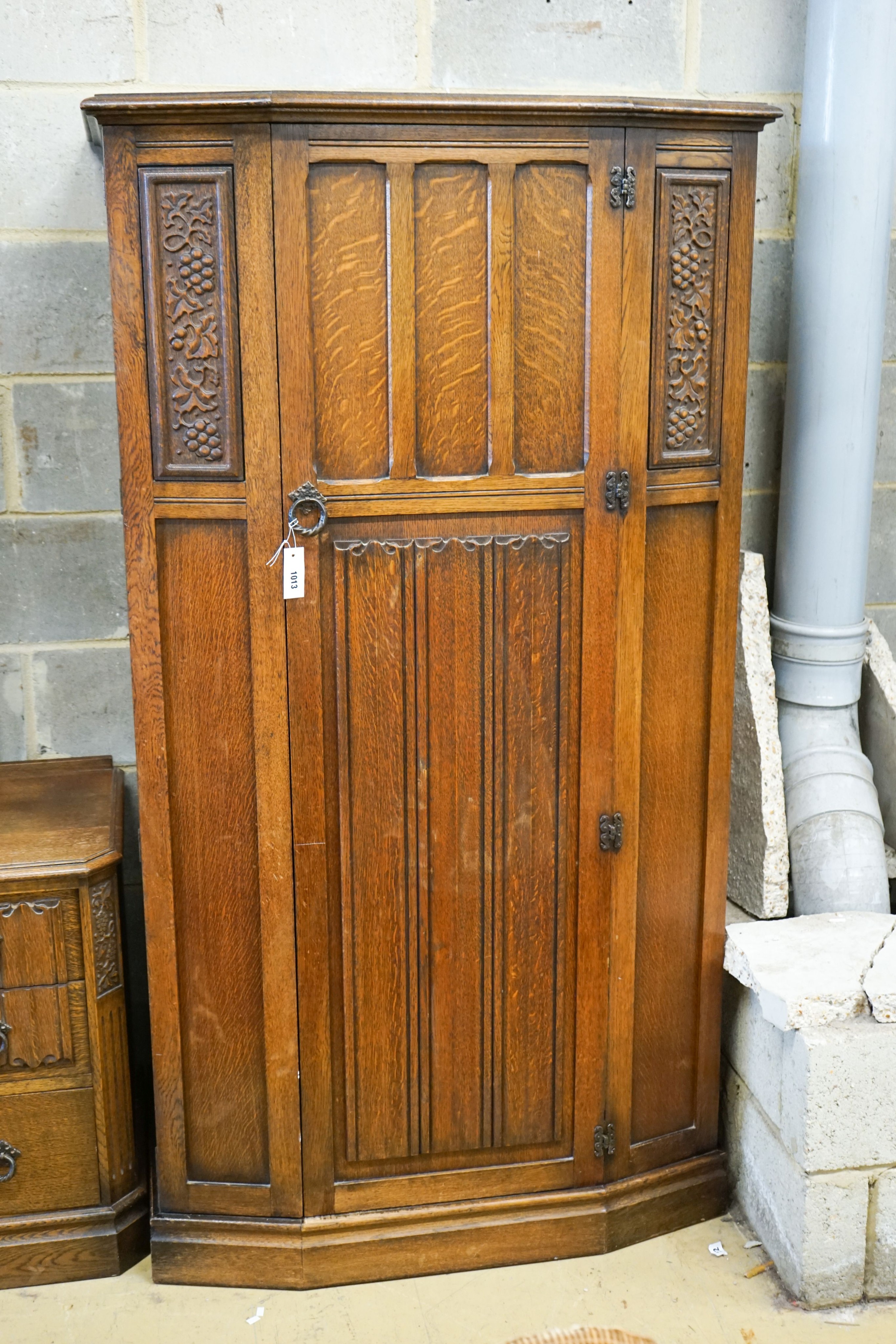 An early 20th century Jacobean revival linenfold moulded oak three piece bedroom suite, larger wardrobe length 128cm, depth 58cm, height 183cm